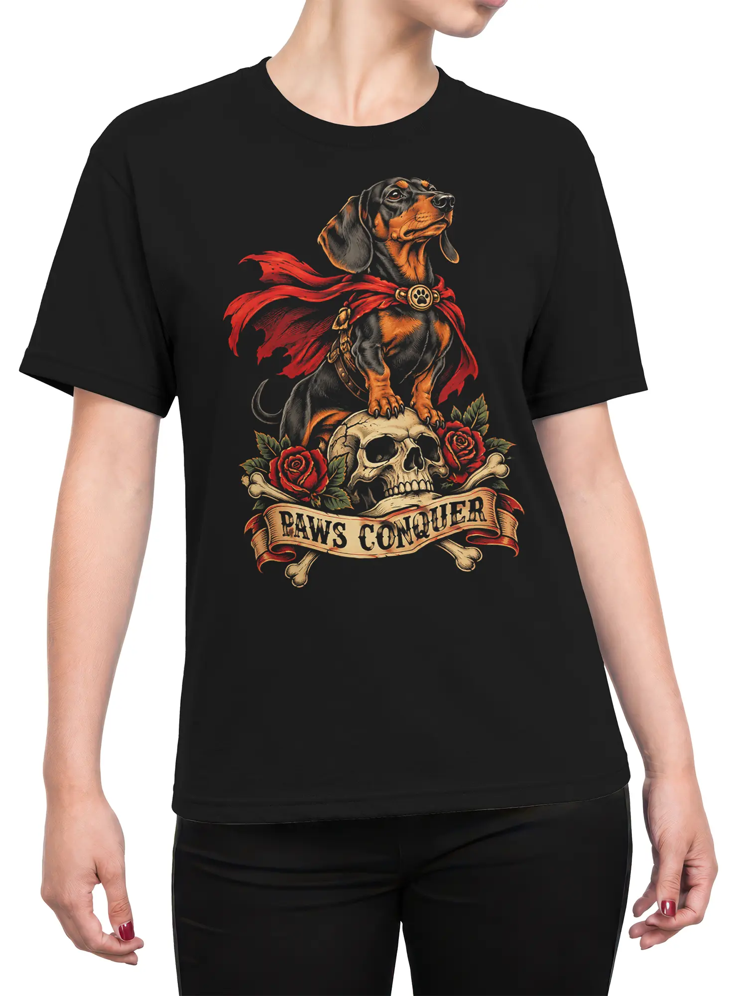 Female torso wearing a black T-shirt with a caped dog, skull, roses, bones, and PAWS CONQUER design