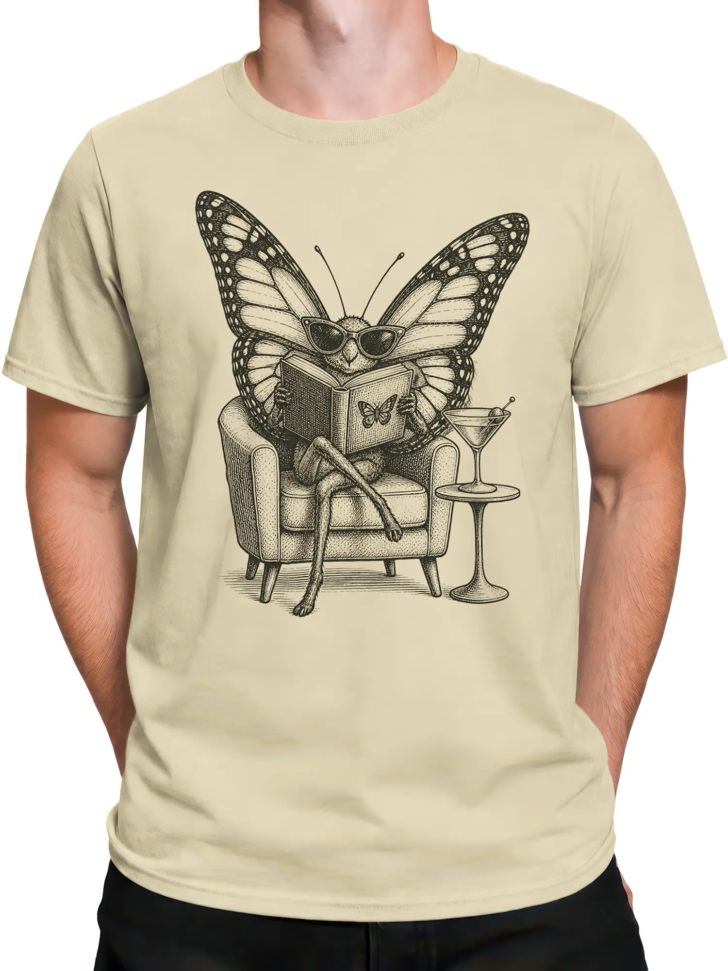 Male torso wearing a beige butterfly graphic tee with a book, sunglasses, armchair, and cocktail design