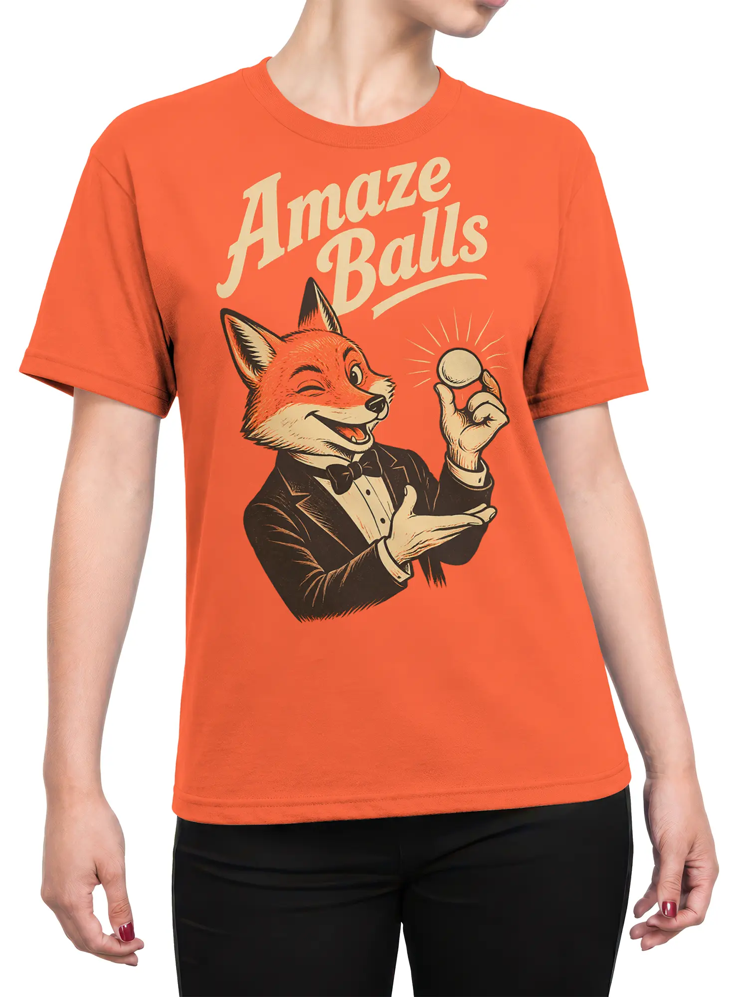 Female torso wearing an orange T-shirt with a dapper fox magician and “Amaze Balls” graphic