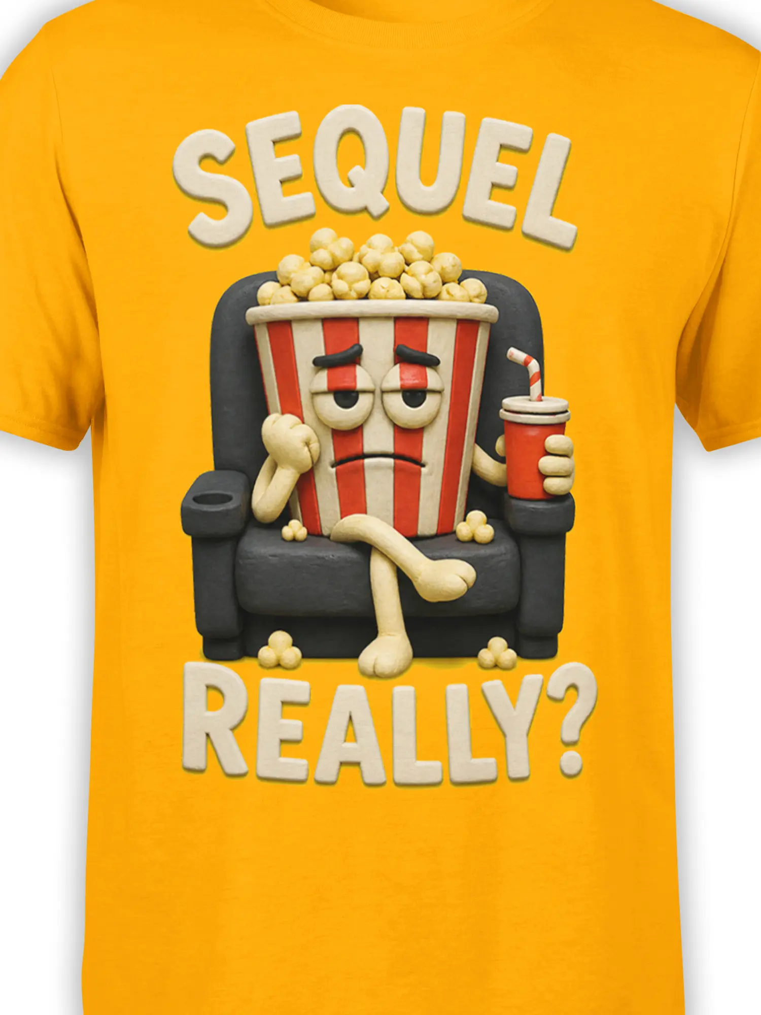 Close-up of the weary popcorn bucket, red drink, striped straw, and “SEQUEL REALLY?” design on a yellow shirt